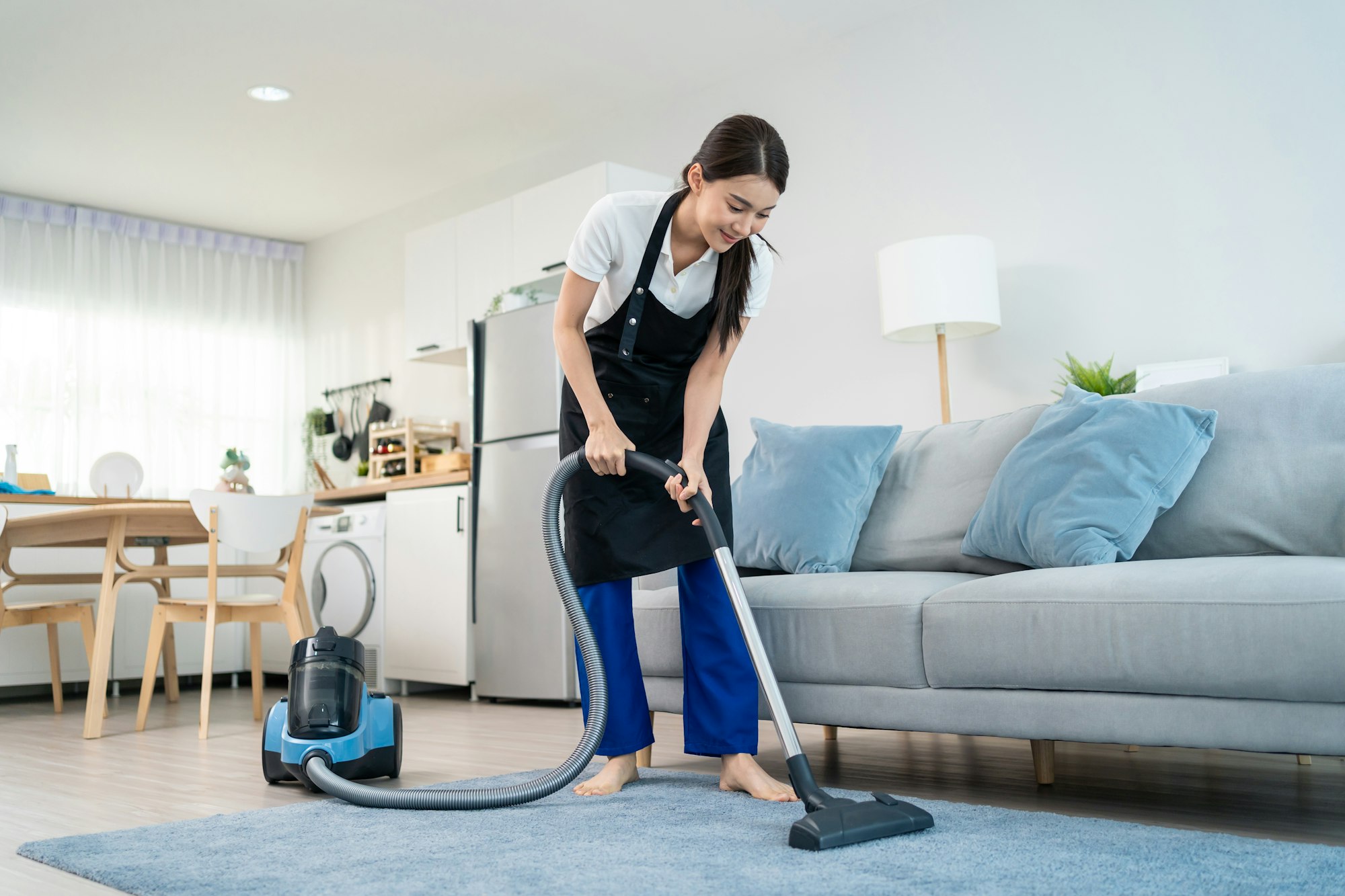 Asian cleaning service woman worker cleaning in living room at home.