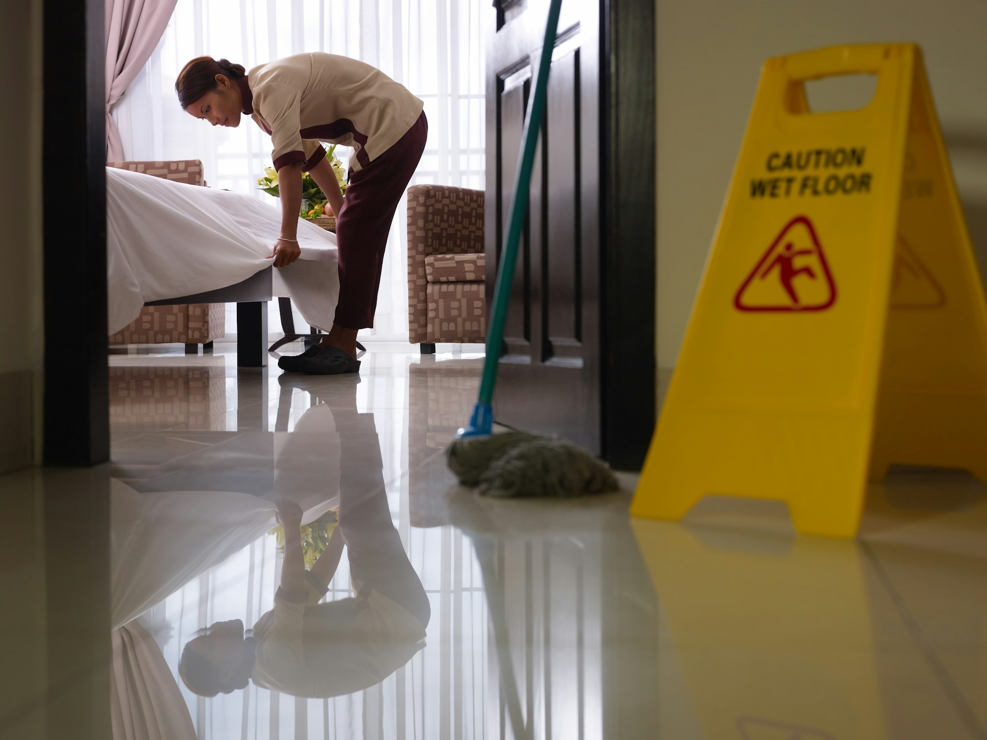 Maid At Work And Cleaning In Luxury Hotel Room